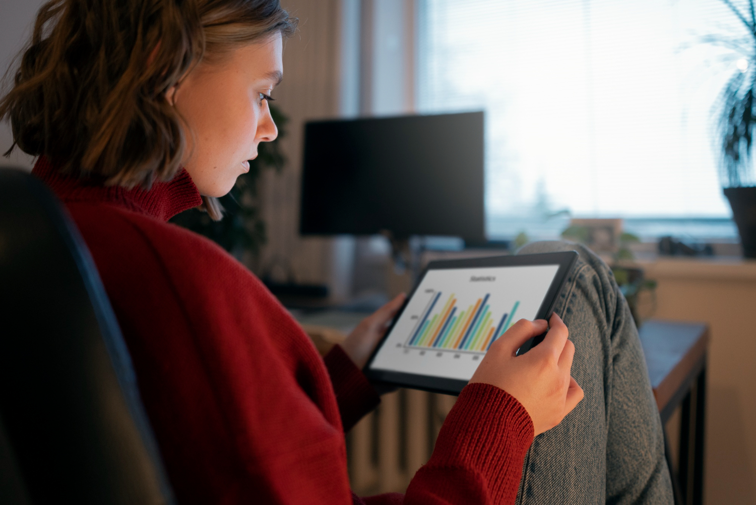 Una persona che analizza grafici su un tablet, simbolo di analisi dei dati e produttività