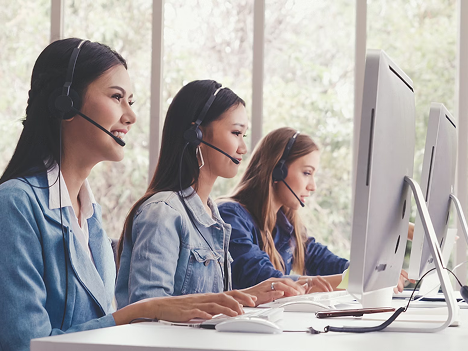 Operatori al lavoro in un call center, utilizzando computer e cuffie per gestire le comunicazioni